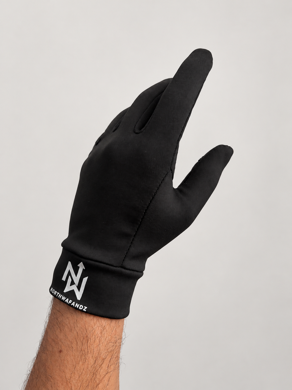 Black NW glove worn on a hand, showing its close fit and white Northwafandz cuff logo